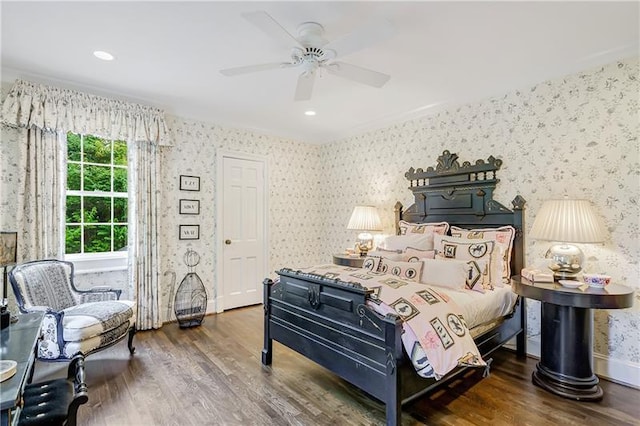 bedroom with wallpapered walls, wood finished floors, and ceiling fan