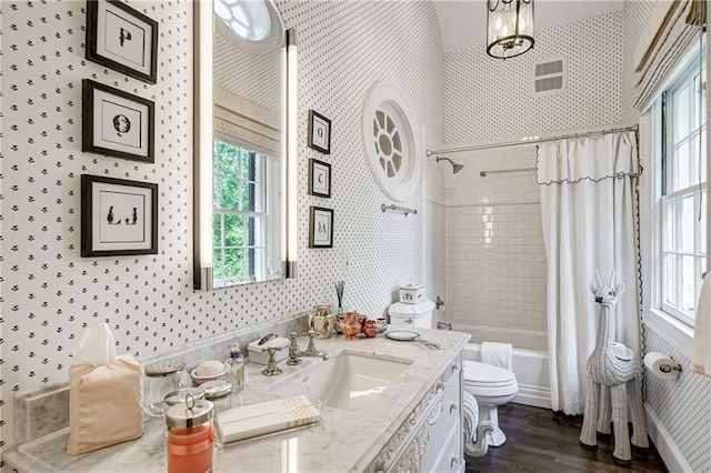 full bathroom with wallpapered walls, toilet, wood finished floors, vanity, and shower / bath combo