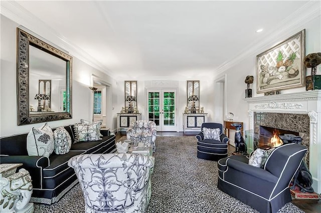 living room featuring french doors, crown molding, and a fireplace