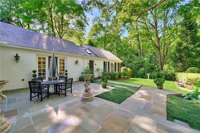 back of house with a patio area, outdoor dining area, and a yard
