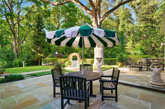 view of patio / terrace with outdoor dining area and view of scattered trees