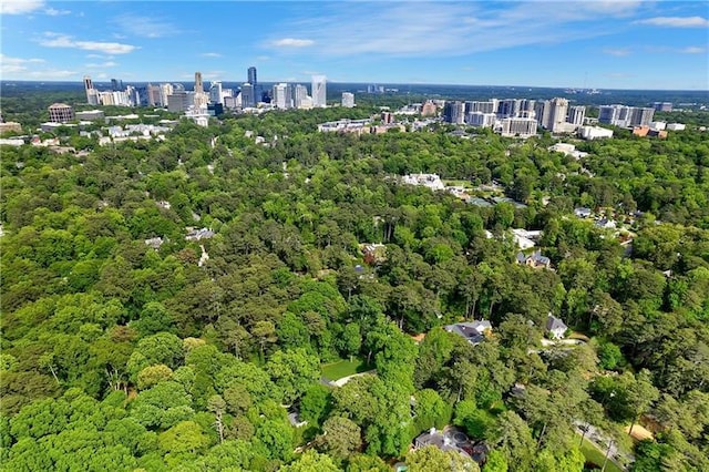 view of property location featuring a heavily wooded area and nearby urban area