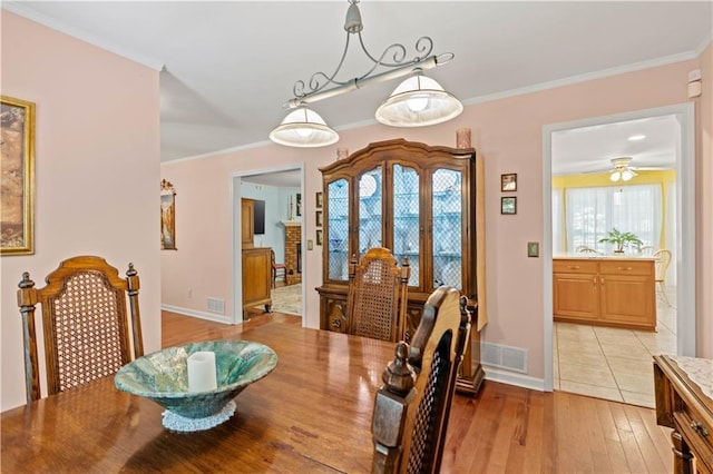 5584 Northwoods Rd, Clermont, GA 30527 - dining area featuring light wood finished floors, baseboards, crown molding, and ceiling fan