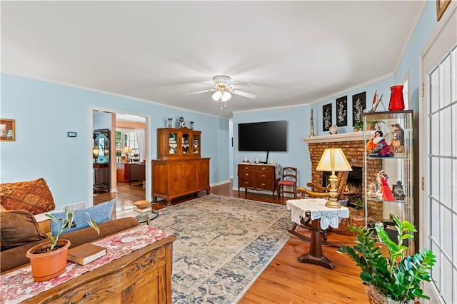 5584 Northwoods Rd, Clermont, GA 30527 - living room featuring crown molding, ceiling fan, wood finished floors, and a brick fireplace