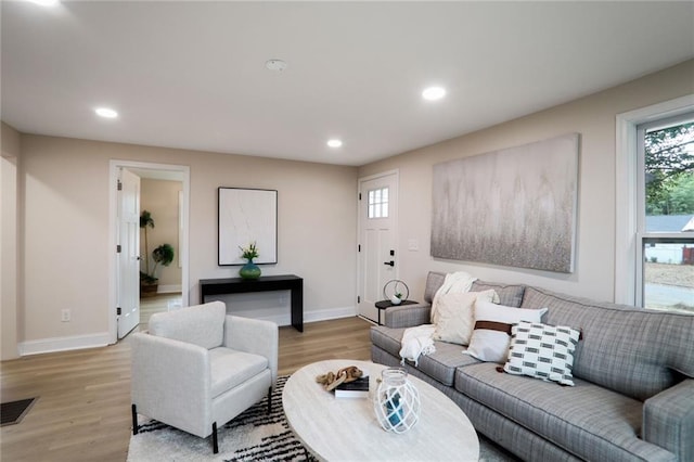 living room with recessed lighting, light wood-style floors, visible vents, and baseboards