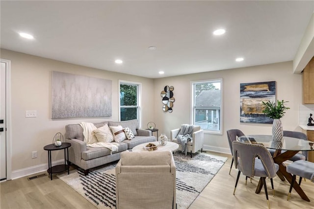 living area with recessed lighting, light wood-type flooring, and baseboards