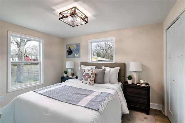 bedroom featuring a closet, baseboards, and wood finished floors