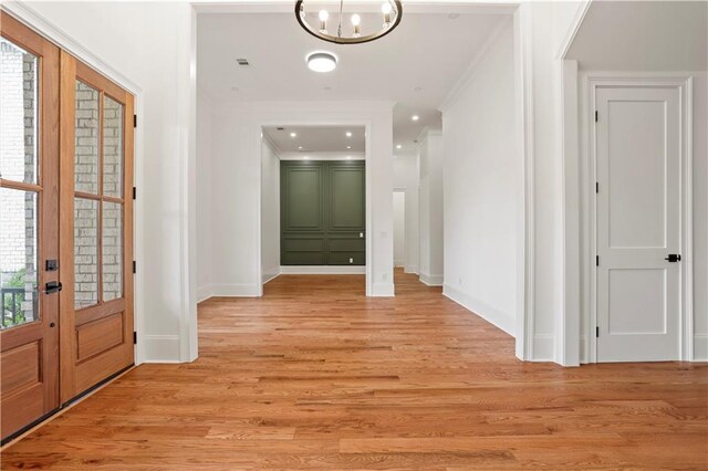 1525 Tapestry Rdg, Lawrenceville, GA 30045 - corridor with crown molding, baseboards, light wood-style floors, a chandelier, and french doors