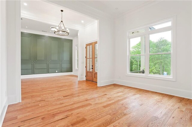 1525 Tapestry Rdg, Lawrenceville, GA 30045 - empty room with baseboards, an inviting chandelier, ornamental molding, and light wood-style floors