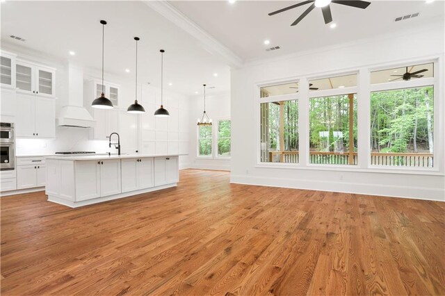 1525 Tapestry Rdg, Lawrenceville, GA 30045 - kitchen with ceiling fan, light countertops, premium range hood, cooktop, and visible vents