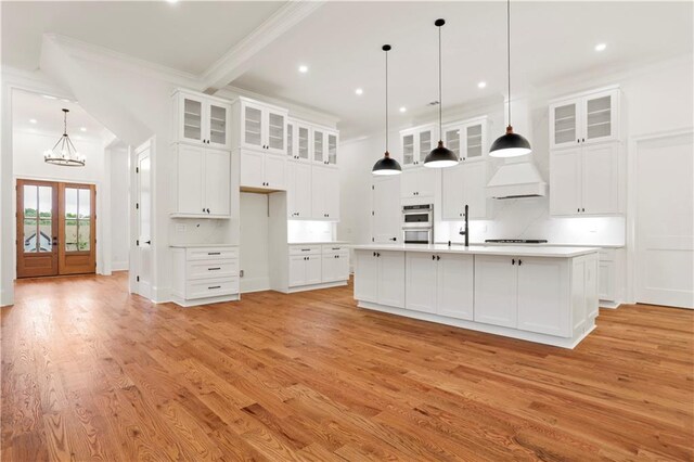 1525 Tapestry Rdg, Lawrenceville, GA 30045 - kitchen with stovetop, crown molding, double oven, light wood finished floors, and a notable chandelier