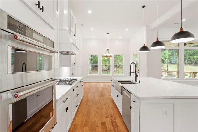 1525 Tapestry Rdg, Lawrenceville, GA 30045 - kitchen featuring a center island with sink, light wood-type flooring, white cabinets, a sink, and appliances with stainless steel finishes