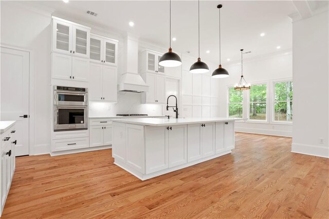 1525 Tapestry Rdg, Lawrenceville, GA 30045 - kitchen with stovetop, visible vents, light countertops, double oven, and light wood-style floors