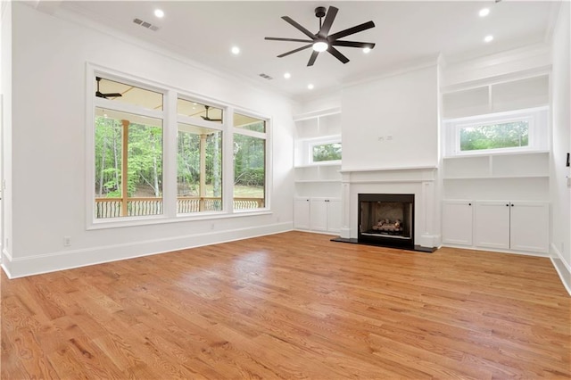 1525 Tapestry Rdg, Lawrenceville, GA 30045 - unfurnished living room featuring crown molding, ceiling fan, a fireplace with raised hearth, and visible vents
