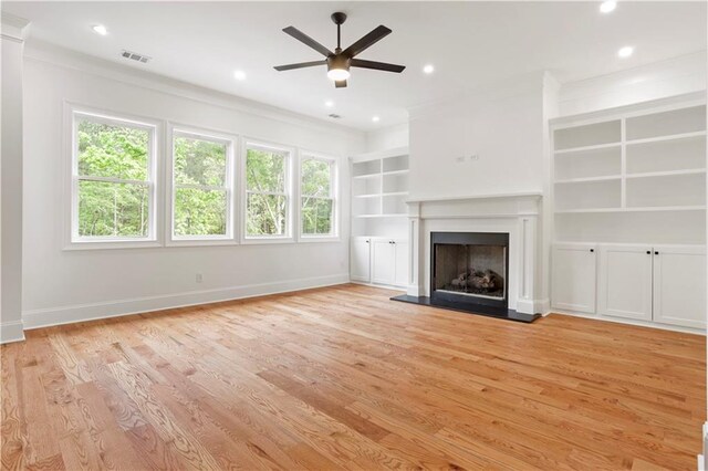 1525 Tapestry Rdg, Lawrenceville, GA 30045 - unfurnished living room featuring ceiling fan, built in features, light wood-type flooring, visible vents, and ornamental molding