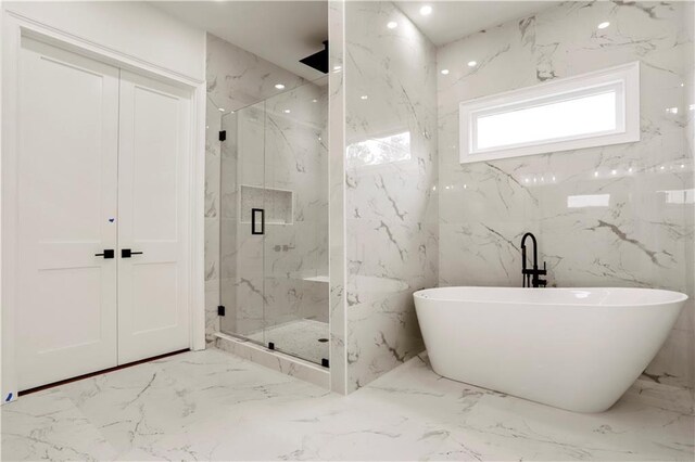 1525 Tapestry Rdg, Lawrenceville, GA 30045 - bathroom with a freestanding bath, stone wall, a marble finish shower, and marble finish floor