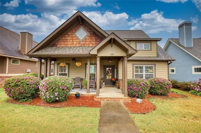 craftsman inspired home featuring a front yard and covered porch