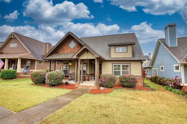 craftsman house with covered porch and a front yard