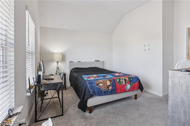 bedroom with vaulted ceiling and light colored carpet