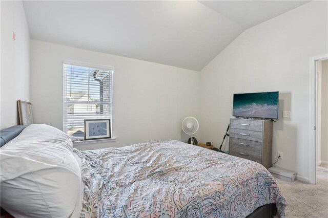 bedroom featuring light carpet and lofted ceiling