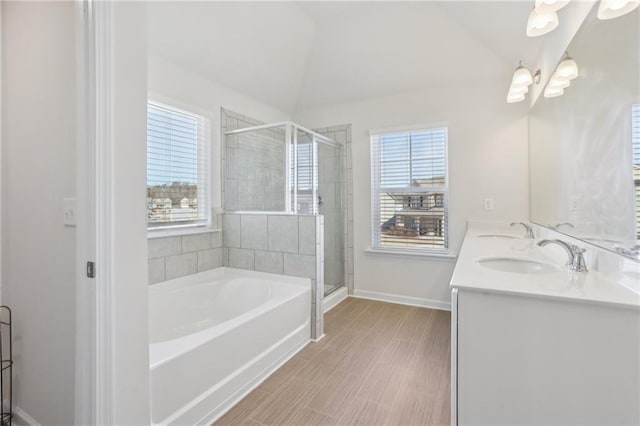 full bath with a sink, a garden tub, a healthy amount of sunlight, and a shower stall