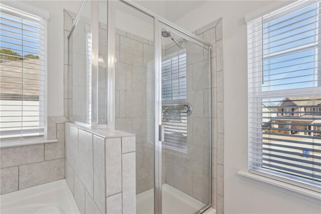 bathroom with tiled shower, vanity, and vaulted ceiling