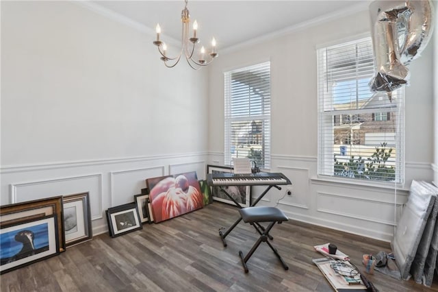 interior space with wood finished floors, an inviting chandelier, and ornamental molding