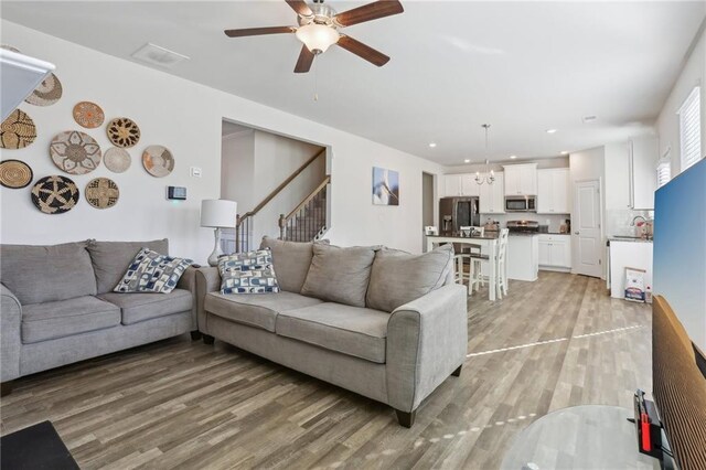 living room featuring dark wood-type flooring and ceiling fan