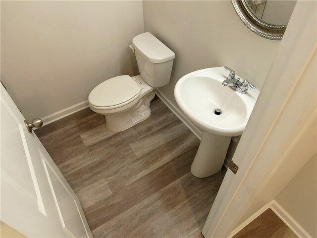 bathroom with toilet and wood-type flooring