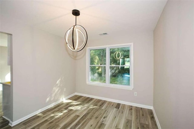 unfurnished room featuring wood-type flooring and a chandelier