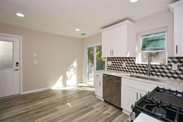 kitchen featuring light hardwood / wood-style floors, dishwasher, black gas stove, sink, and white cabinetry