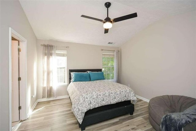 bedroom featuring ceiling fan, light hardwood / wood-style flooring, and lofted ceiling