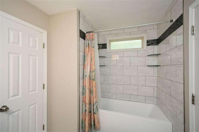 bathroom featuring shower / bath combo and a textured ceiling