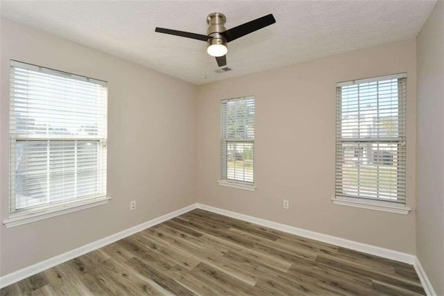 unfurnished room with a textured ceiling, dark hardwood / wood-style flooring, and ceiling fan