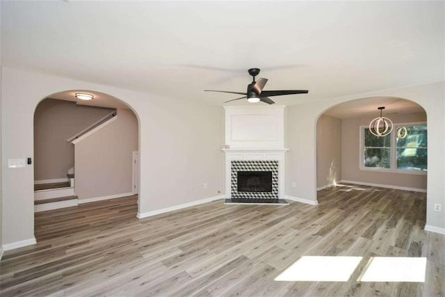 unfurnished living room with hardwood / wood-style flooring, ceiling fan, and a tile fireplace