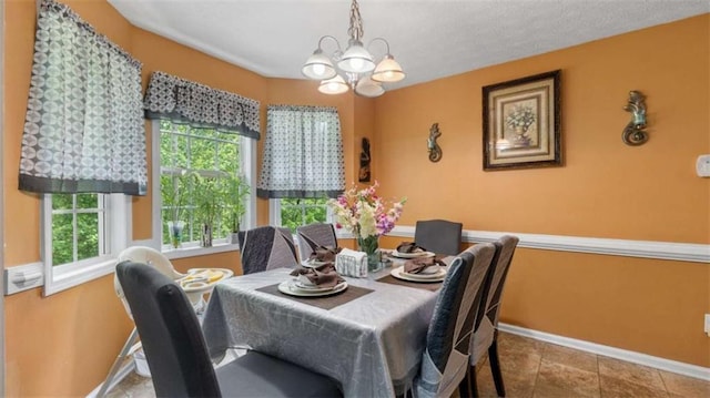 dining space featuring baseboards, tile patterned floors, and a chandelier
