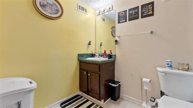 half bathroom with vanity, baseboards, and toilet