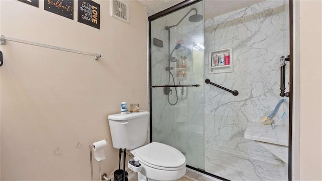 bathroom with toilet, visible vents, and a marble finish shower