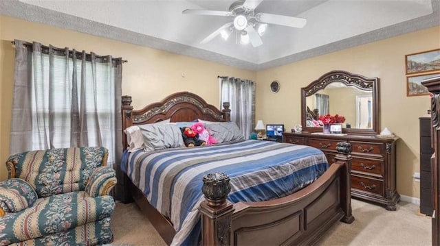 bedroom with light colored carpet, baseboards, and ceiling fan