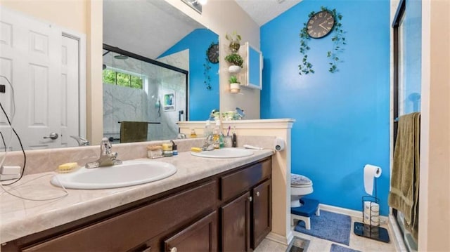 full bathroom with double vanity, a sink, lofted ceiling, and a stall shower