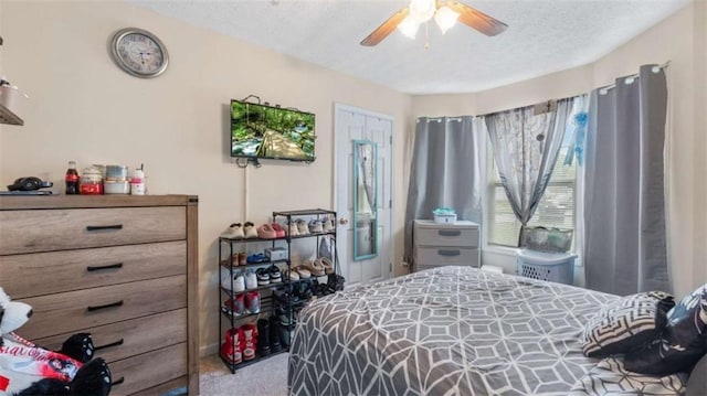 bedroom featuring a ceiling fan, carpet flooring, and a textured ceiling