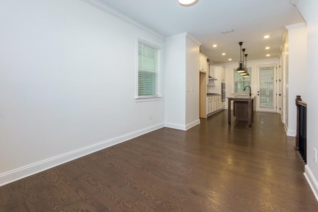 interior space with sink, crown molding, dark wood-type flooring, and a healthy amount of sunlight