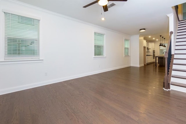 unfurnished living room featuring ornamental molding, a healthy amount of sunlight, ceiling fan, and dark hardwood / wood-style flooring