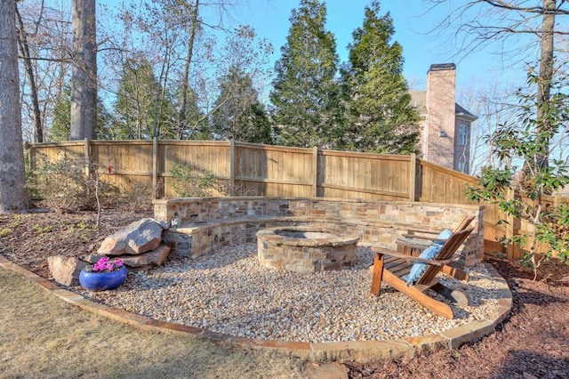 view of yard featuring a fenced backyard and a fire pit