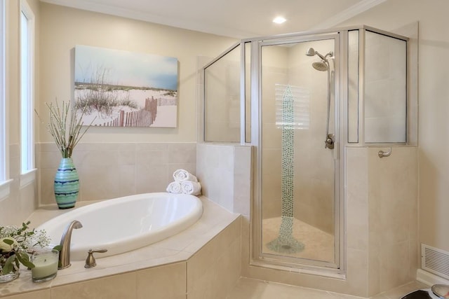 bathroom featuring visible vents, a stall shower, and a bath