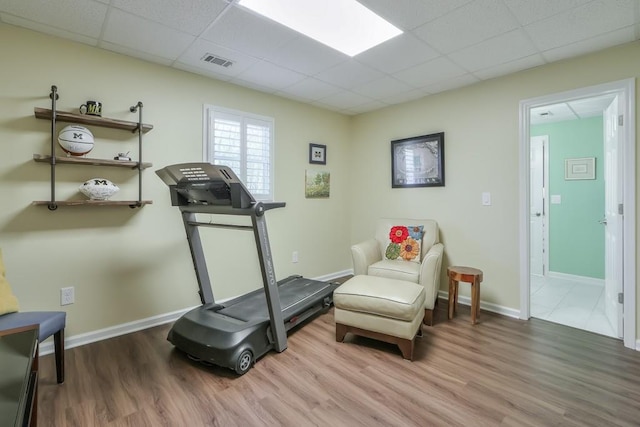 exercise room featuring a drop ceiling, wood finished floors, and visible vents