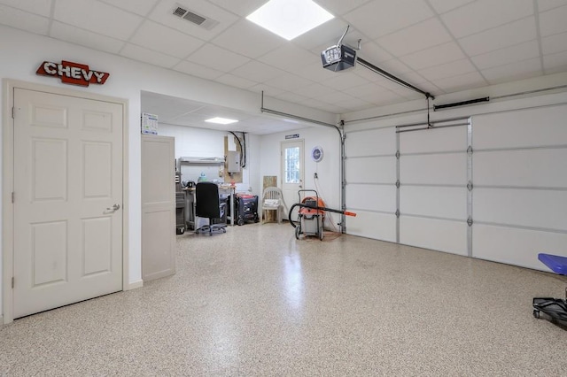 garage with visible vents, electric panel, and a garage door opener