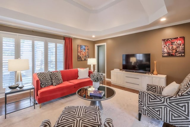 living room with ornamental molding, a raised ceiling, and baseboards