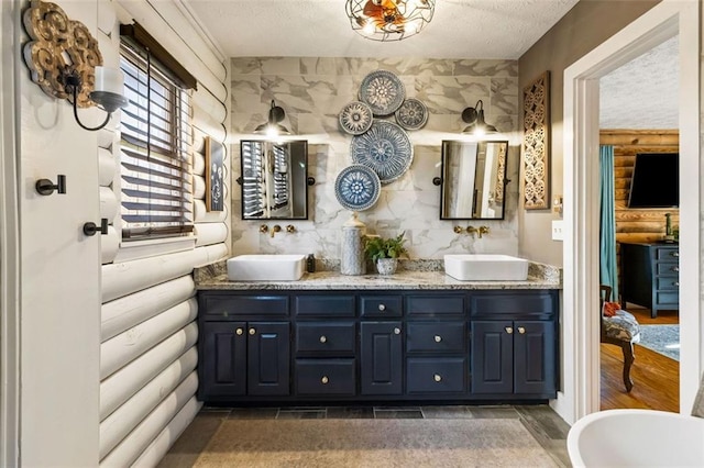 bathroom featuring vanity, a textured ceiling, and a bathing tub