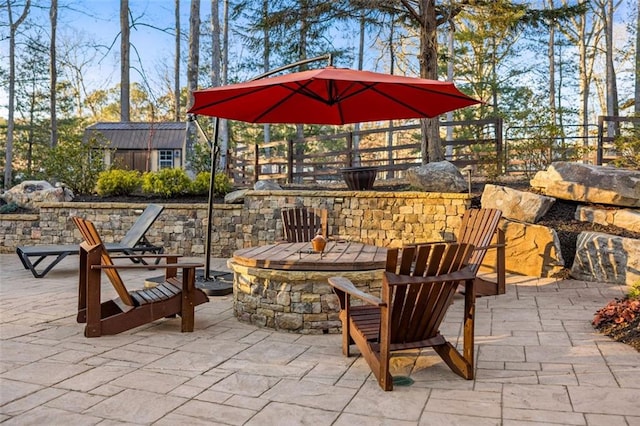 view of patio / terrace featuring a fire pit and a storage shed